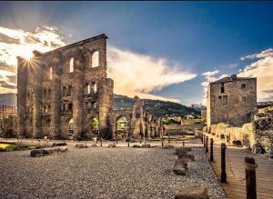 a large stone building with a cloudy sky in the background at Maison Bodroz appartamento Charme in Aosta