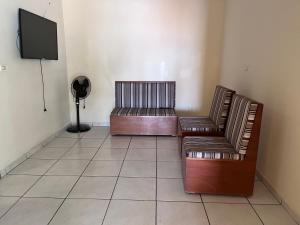 2 lederen stoelen en een televisie in een kamer bij Pousada Lopes na Fama in Goiânia