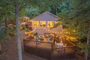 a house with a deck with lights on it at Lakefront with Dock and Hot Tub! in Toccoa