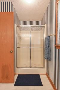 a shower with a glass door in a room at Lakefront with Dock and Hot Tub! in Toccoa