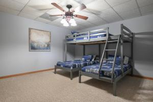 two bunk beds in a room with a ceiling fan at Lakefront with Dock and Hot Tub! in Toccoa