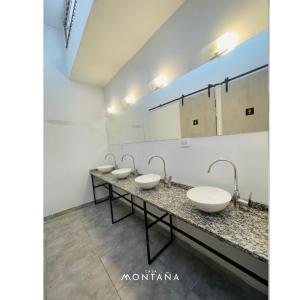 una fila de lavabos en un baño con una fila de espejos en Casa Montaña en Salta