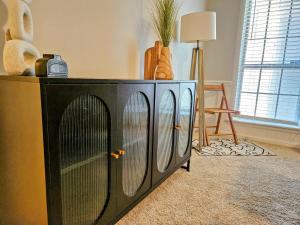 a large black cabinet with doors in a room at VillaQuèFrancia near Elvis Presley's Graceland 6 mins from Airport in Memphis