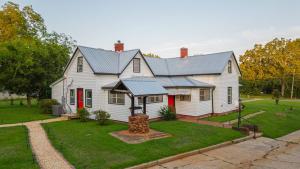 a white house with a metal roof at The Bulldog Farmhouse 100 year old home in Athens