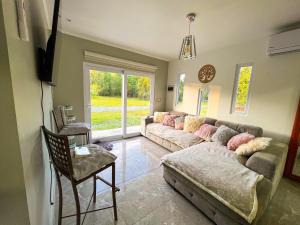 ein Wohnzimmer mit einem großen Sofa und einem Stuhl in der Unterkunft Cabañas Maravillas de Quetroleufu in Pucón