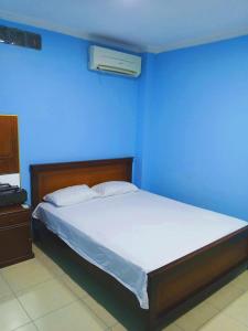 a blue bedroom with a bed with a blue wall at Villa Meyling, Tu Hogar en la Playa Crucita! in Crucita