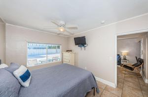 um quarto com uma cama, uma ventoinha de tecto e uma janela em Blue Water Beachside villa 3 em Clearwater Beach