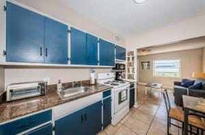 uma cozinha com armários azuis e um lavatório em Blue Water Beachside villa 3 em Clearwater Beach