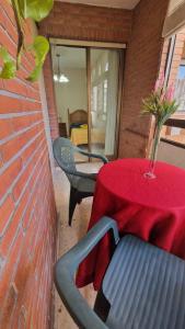 a red table with chairs and a table with a vase on it at Habitación en el Centro de Alicante in Alicante