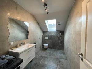 een badkamer met een wastafel en een toilet bij Cozy Apartment near Vienna Airport in Schwechat