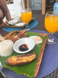 a table with a plate of food with a banana and rice at Borac Bay View in Borac