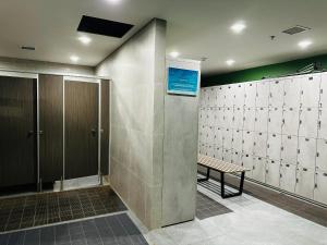 une salle de bains avec un banc et un mur de stalles dans l'établissement Armin Homes Ecopark Red Riverview Sky Oasis, à Kim Quan