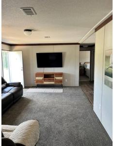 a living room with a couch and a flat screen tv at Ranch Road Retreat in Clermont