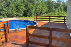 a wooden deck with a pool and a bench on it at Ranch Road Retreat in Clermont