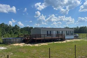 a mobile home with a porch and a deck at Ranch Road Retreat in Clermont