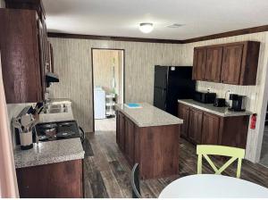 a kitchen with wooden cabinets and a black refrigerator at Ranch Road Retreat in Clermont