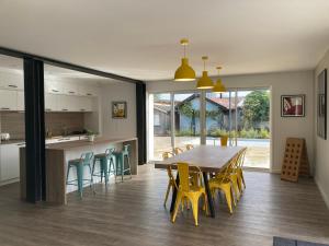 a kitchen and dining room with a table and chairs at Chai Nous - votre villa au cœur des Landes - classée 4 étoiles in Rion-des-Landes +37 photos