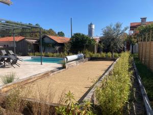 un patio trasero con piscina y jardín en Chai Nous, en Rion-des-Landes