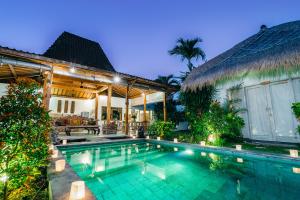 a swimming pool in front of a house at Villa Niri in Seminyak