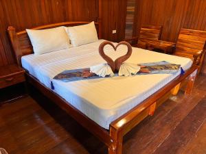 Una cama con dos cisnes en forma de corazón en Diamond Beach Resort, en Ao Nam Mao