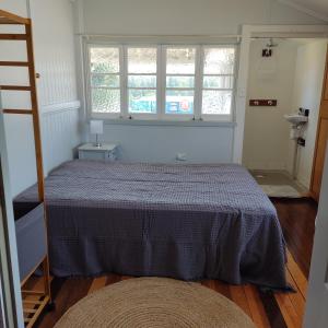 um quarto com uma cama, uma janela e uma escada em La Maison Blanche em Atherton
