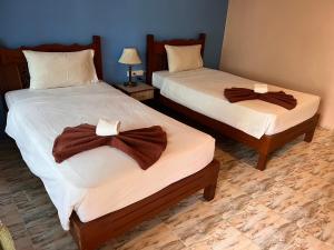 two beds with brown robes on them in a room at Diamond Beach Resort in Ao Nam Mao