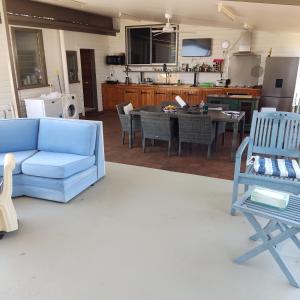 uma sala de estar com um sofá azul e uma cozinha em La Maison Blanche em Atherton
