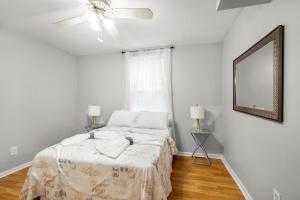 a white bedroom with a bed and a mirror at 1 Bdrm Flat In Bella Vista in Philadelphia