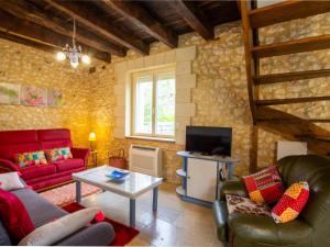 ein Wohnzimmer mit einem roten Sofa und einem TV in der Unterkunft Gîte Saint-Pierre-de-Chignac, 3 pièces, 6 personnes - FR-1-616-18 in Saint-Pierre-de-Chignac
