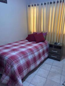 a bedroom with a bed with a red plaid blanket at Habitación privada y céntrica /cómoda! in Santa Cruz de la Sierra