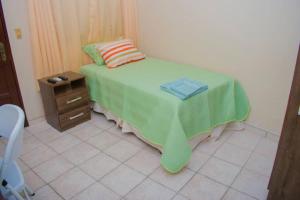 a bedroom with a bed with a green blanket on it at Habitación privada y céntrica /cómoda! in Santa Cruz de la Sierra