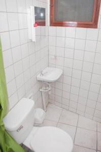 a white bathroom with a toilet and a sink at Habitación privada y céntrica /cómoda! in Santa Cruz de la Sierra