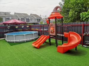 a childrens playground with a slide and a pool at Red Triangle Cottage Roomstay Kerteh Paka in Kampong Pengkalan Pangan