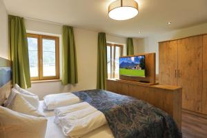 a bedroom with a bed and a flat screen tv at Ferienhof Oberhuber in Staudach-Egerndach