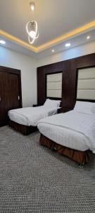 two beds in a large room with at إعمار الشرفةللشقق المفروشه in Najran