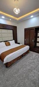1 dormitorio con 1 cama grande en una habitación en إعمار الشرفةللشقق المفروشه, en Najrán