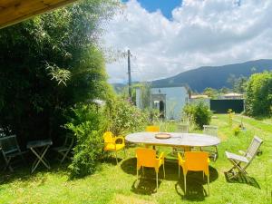 a patio with a table and chairs in the grass at Karma oasis in Saint-Joseph