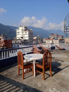 un tavolo e due sedie seduti sopra un tetto di Hotel Blue moon Pokhara a Pokhara