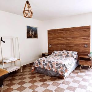1 dormitorio con cama y cabecero de madera en VILLA D-SPITIA Apartamentos en renta, en Atlixco