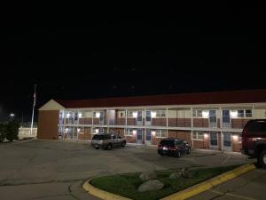 a large building with cars parked in a parking lot at Colonial Inn in Dyersville