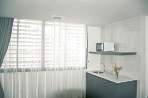 a white kitchen with a sink and a window at Grandview Residence in Chiang Mai