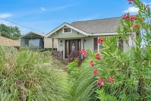 a house with pink flowers in front of it at River Cottage near the Airport in Saint Rose