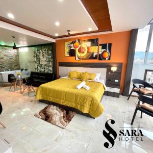 een slaapkamer met een bed met een oranje muur bij SARA HOTEL IBARRA in Ibarra