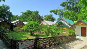 a row of houses behind a fence at Jyoti Home Bamboo Garden Lodge in Majuli