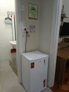 um frigorífico branco num quarto com um lavatório em Lindo Loft na Cinelândia no Rio de Janeiro