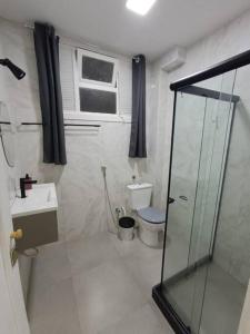 uma casa de banho com um chuveiro, um WC e uma janela. em Lindo Loft na Cinelândia no Rio de Janeiro