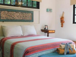 a bedroom with a bed with a teddy bear on it at Hotel Boutique Casa Flor de Mayo in Mérida