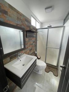 een badkamer met een wastafel en een toilet bij SARA HOTEL IBARRA in Ibarra