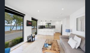 a living room with a couch and a kitchen at Bribie Waters Apartment in Bongaree
