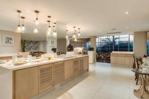 a kitchen with a large island with a counter top at Protea Hotel by Marriott Karridene Beach in Amanzimtoti